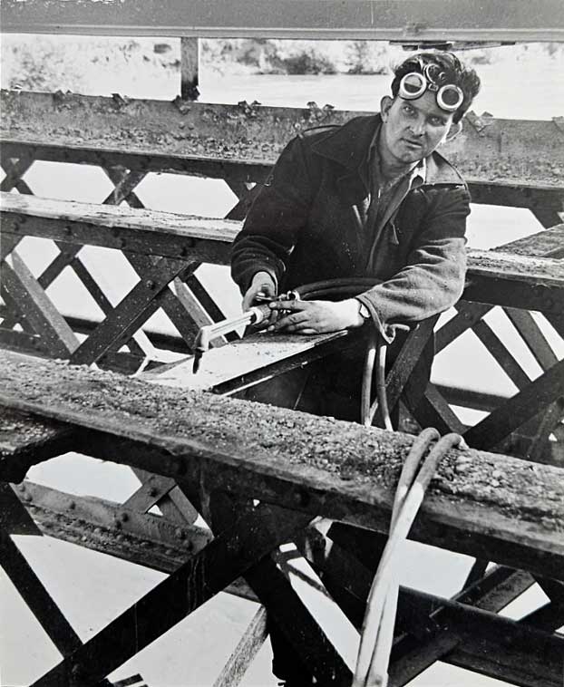 A photo of a welder using an acetylene torch to remove the old Knightsford bridge girders, during its demolition and the building of the new footbridge; photo taken on the 26th September, 1958.